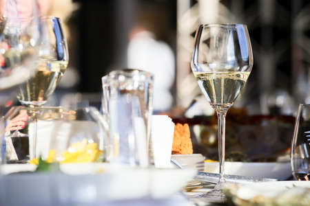 Glassware, glasses for white wine on a table in the restaurant. Banquet, cutlery, table setting.の写真素材