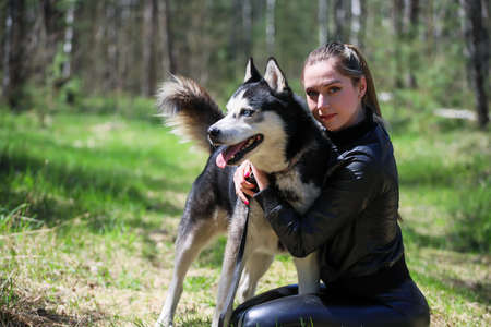 Cute girl hugs the husky. Husky are best friends.