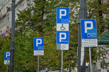 WARSAW. POLAND - AUGUST 2015: Road parking signs, parking for cars, parking for disabled people. Against the background of a green trees. High quality photoのeditorial素材