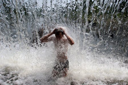 Belarus. Minsk - 11.06.2010: A child bathes in a city fountain in hot summer.のeditorial素材