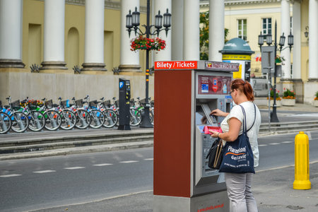 WARSAW. POLAND - AUGUST 2015: A girl buys a ticket at the ZTM vending machine for public transport in Warsaw. Warm summer in Warsaw.のeditorial素材