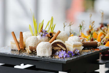 Set of sweet desserts for catering, dessert on the black plate.の写真素材