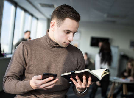 Portrait of a young businessman with the notepad in his hands.の写真素材