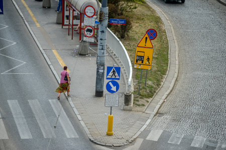 WARSAW. POLAND - AUGUST 2015: Crossroads, stop for public transport. Road signs. The woman crosses the road in Warsaw.のeditorial素材