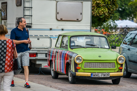 WARSAW. POLAND - AUGUST 2015: Vintage, antique, old green car on the streets of Warsaw. People are looking at the old car. High quality photoのeditorial素材