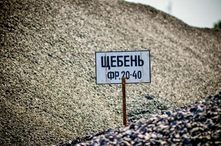 Sand and crushed stone tablets on the mountains of sand and crushed stone for the production of asphalt. Asphalt plant. Blue sky.の写真素材