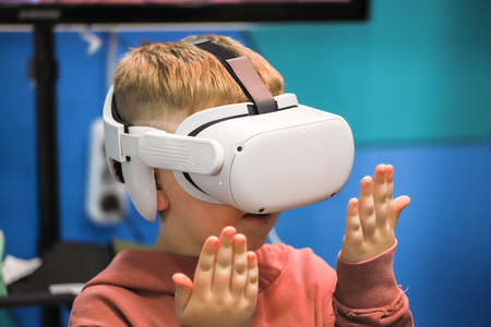 Boy holding his hands in front of virtual reality headsetの写真素材