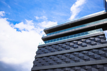 New building with original facade against the background of blue sky and clouds.の写真素材