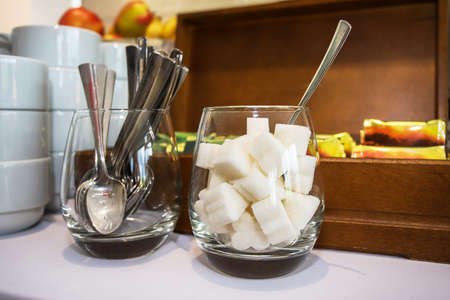 Sugar and teaspoons on the background of a box with tea at a food court.の写真素材