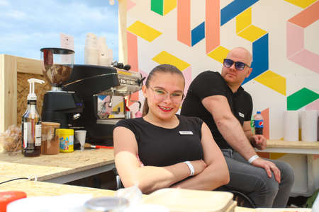 Minsk. Belarus - 06.04.2021: A disabled woman and a man in wheelchairs work in a cafe in the park.のeditorial素材