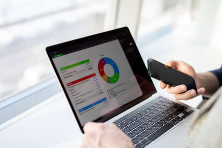 The laptop is in the hands of businessmen. Diagram on a PC screen.