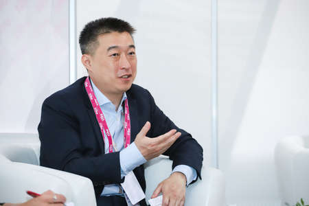 Minsk. Belarus: 06.03.2021 - An Asian man in a white shirt, black suit in the pavilion of the Tibo exhibition in Minsk. High quality photoのeditorial素材
