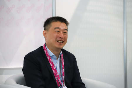 Minsk. Belarus: 06.03.2021 - An Asian man in a white shirt, black suit in the pavilion of the Tibo exhibition in Minsk. High quality photoのeditorial素材