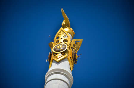 Nur-Sultan. Kazakhstan: 04.09.2013 - Golden monument in the blue sky. Golden statue on a white marble clone.のeditorial素材