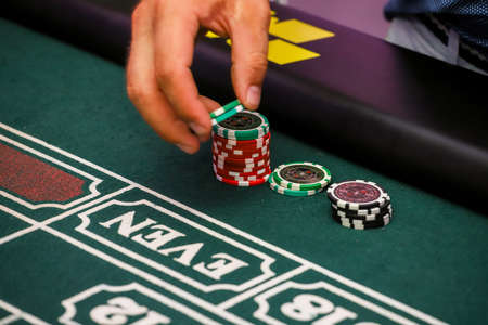 Minsk. Belarus - 25.06.2021 - Chips on a casino playing table. Green table cover.のeditorial素材
