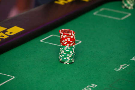 Minsk. Belarus - 25.06.2021 - Casino chips on a green gambling table. High quality photoのeditorial素材