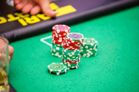 Minsk. Belarus - 25.06.2021 - Casino chips on a green gambling table. High quality photoのeditorial素材