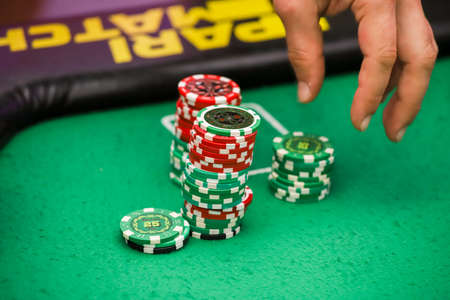 Minsk. Belarus - 25.06.2021 - Casino chips on a green gambling table. High quality photoのeditorial素材