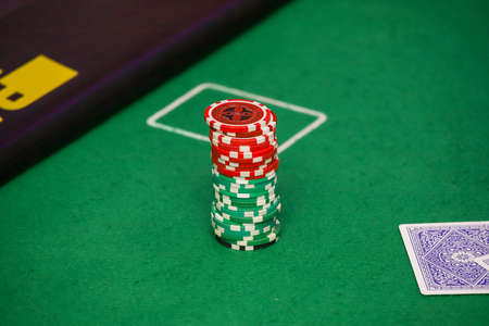 Minsk. Belarus - 25.06.2021 - Casino chips on a green gambling table. High quality photoのeditorial素材