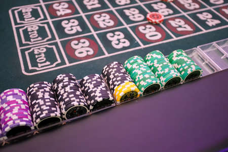 Minsk. Belarus - 25.06.2021 - Chips on a casino playing table. Green table cover.のeditorial素材