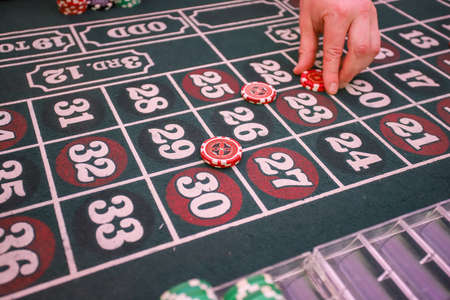 Minsk. Belarus - 25.06.2021 - Chips on a casino playing table. Green table cover.のeditorial素材