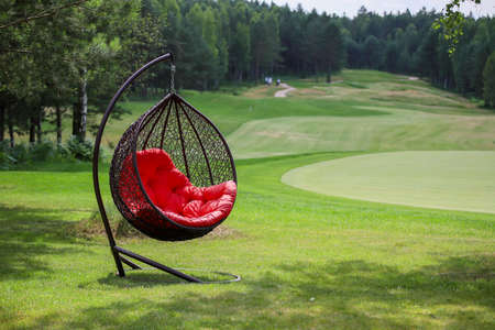 Hanging chair with red plaid on a golf course.の写真素材