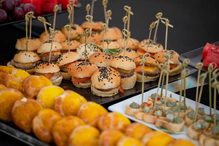 Mini burgers with black sesame seeds at the buffet table.の写真素材
