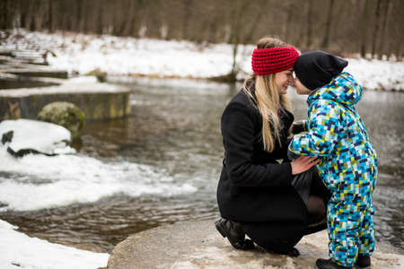 Young mother with her son in winter on a lake.の写真素材