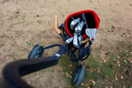 Minsk. Belarus - 25.07.2021 - Golf clubs in a red bag close-up green grass backgroundのeditorial素材