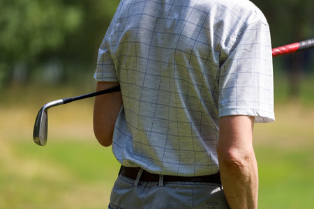 Minsk. Belarus 25.07.2021 - Golfer with a putter on the field. Nearby there is a forest, green grass.のeditorial素材