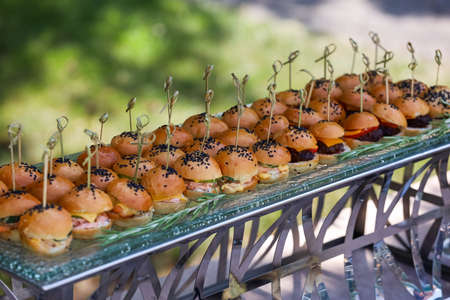 Mini burgers with black sesame seeds at the buffet table.の写真素材