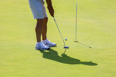 Minsk. Belarus 18.07.2021 - Golfer with a putter on the field. Nearby there is a forest, green...
