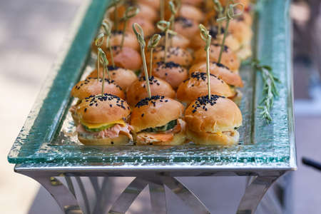 Mini burgers with black sesame seeds at the buffet table.の写真素材