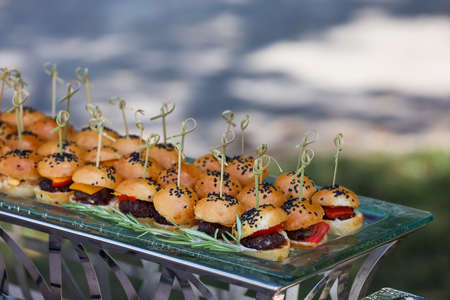 Mini burgers with black sesame seeds at the buffet table.の写真素材