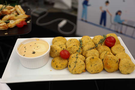 Yellow cutlets with sauce. Catering, food on buffet table on white plate in a street. High quality photoの写真素材