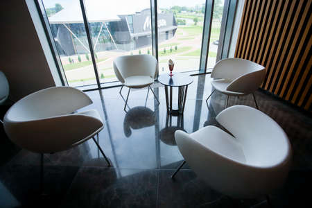 White armchairs in the interior, panoramic windows, wooden walls.の写真素材