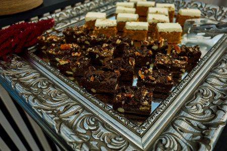 Cookie slices with nuts, cocoa and caramel at buffet table, served on the silver trayの写真素材