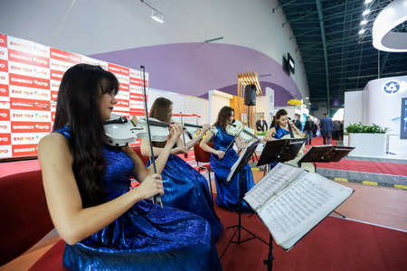 Minsk. Belarus: 12.10.2021 - Girls play violins in blue dresses on the Energy Expo exhibition in Minsk.のeditorial素材