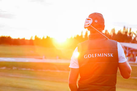 Minsk. Belarus - 03.08.2021 - Golfer at sunset with the golf club in hand. High quality photoのeditorial素材