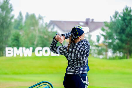 Golfer with a putter on the field. Nearby there is a forest, green grass.の写真素材