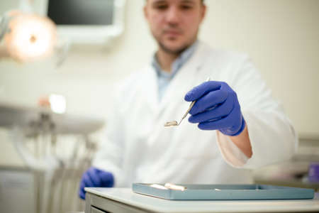 Tools in the hands of the dentist. Blue glovesの写真素材