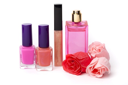 Lip gloss, perfume, nail polish bottles and rose flowers on white backgroundの写真素材