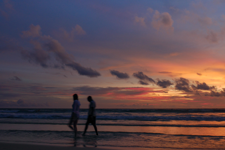 blurred people at the beach with twilight cloudy sky.の写真素材