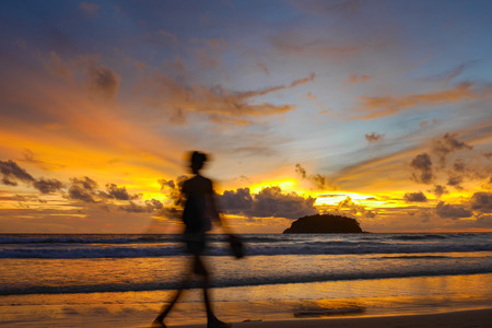 blurred people at the beach with twilight cloudy sky.There is an island in the seaの写真素材