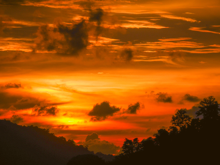 Twilight beautiful evening cloudy sky  after sunset background . There are silhouette mountains and trees.の写真素材