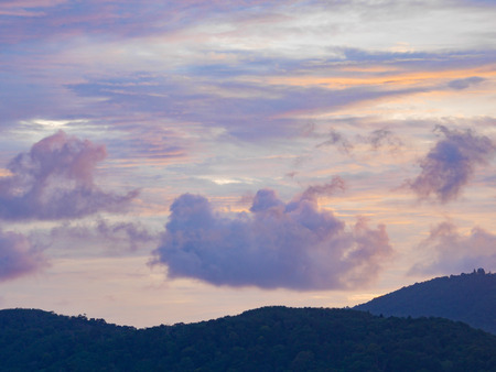 Twilight beautiful evening cloudy sky  after sunset background . There are silhouette mountains and trees.の写真素材