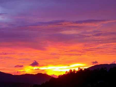Twilight beautiful evening cloudy sky  after sunset background . There are silhouette mountains and trees.の写真素材