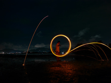 light lines of steel wool with long exposure, speed motion abstract background in the dark nightの写真素材