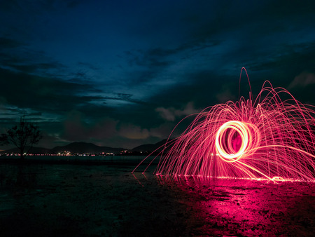 light lines of steel wool with long exposure, speed motion abstract background in the dark night