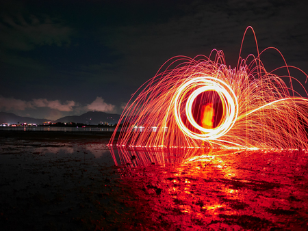 light lines of steel wool with long exposure, speed motion abstract background in the dark nightの写真素材
